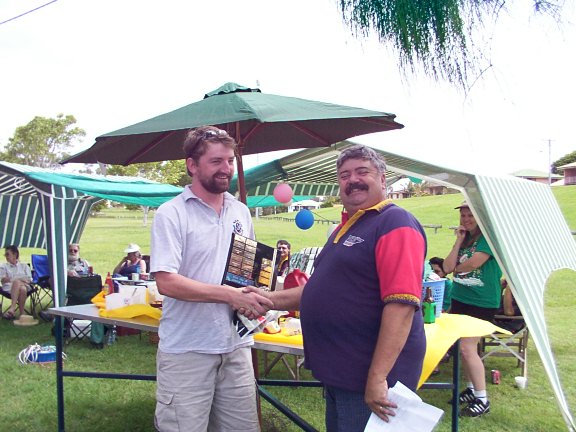 Garth receiving the trophy from Rogo